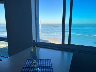 a glass vase on a table with a view of the ocean at 401 Pip's Place in Strand