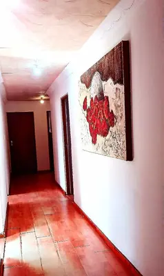 a hallway with a painting on a white wall at Peace Accommodation B&B in Silver Sands