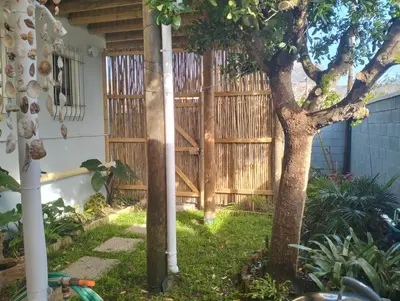 a wooden fence in a yard with a tree at Garden es Cape in Pringle Bay