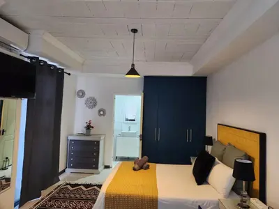 a bedroom with a bed with a teddy bear on it at G's Apartments Cape Town in Windsor Park