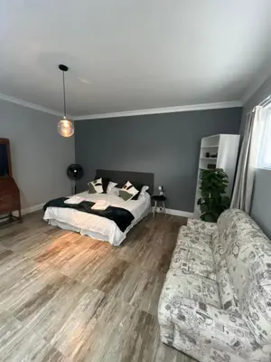 a bedroom with a bed and a couch at Spacious Bachelor Die Boord in Stellenbosch