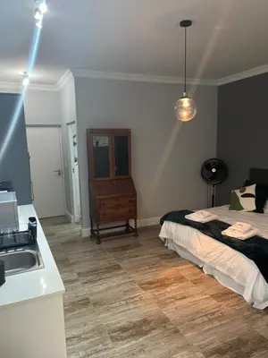 a bedroom with a bed and a sink in it at Spacious Bachelor Die Boord in Stellenbosch