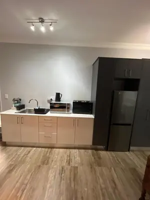 an empty kitchen with a sink and a refrigerator at Spacious Bachelor Die Boord in Stellenbosch