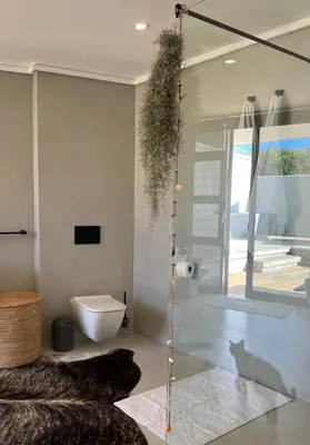 a bathroom with a toilet and a cat in a room at Villa Victoria in Paarl