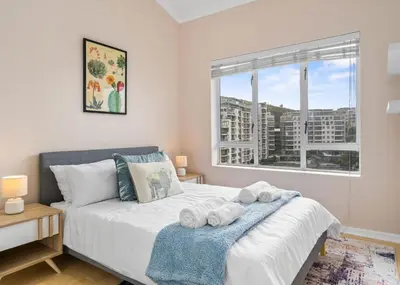 a bedroom with a bed with towels on it at The Tygervalley Escape in Cape Town