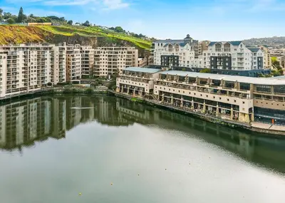 a group of buildings next to a body of water at The Tygervalley Escape in Cape Town