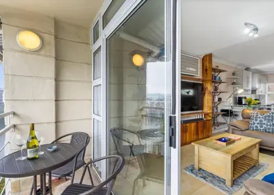 a room with a table and chairs and a living room at The Tygervalley Escape in Cape Town
