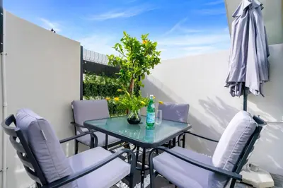 a small balcony with a glass table and chairs at Studio on North in Cape Town
