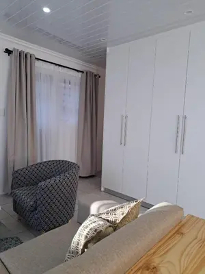 a living room with a couch and a chair at Garden studio flat in Panorama