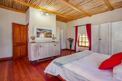 a bedroom with a large bed and a wooden ceiling at Calais Wine Estate in Paarl