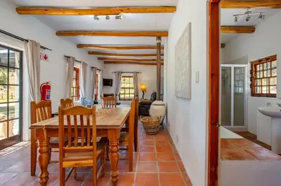 a kitchen and dining room with a wooden table and chairs at Calais Wine Estate in Paarl
