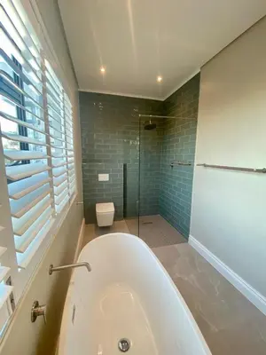 a bathroom with a tub and a shower and a toilet at Luxury Home in Security Golf Estate with Ocean Terrace in Cape Town