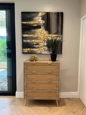 a dresser in a room with a painting on the wall at Luxury Home in Security Golf Estate with Ocean Terrace in Cape Town