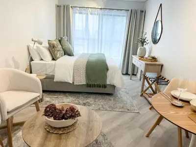 a living room with a bed and a table and chairs at Platform 133 2 Tabak in Paarl
