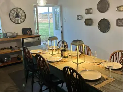 a table with chairs and plates and glasses on it at Ceres Hideaways