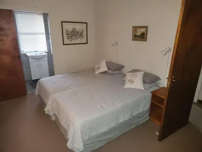 a bedroom with a white bed and a sink at Fairway Corner in Villiersdorp