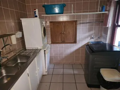 a small kitchen with a sink and a microwave at Fairway Corner in Villiersdorp