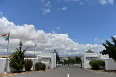 a white building with a flag in front of it at Fairway Corner in Villiersdorp