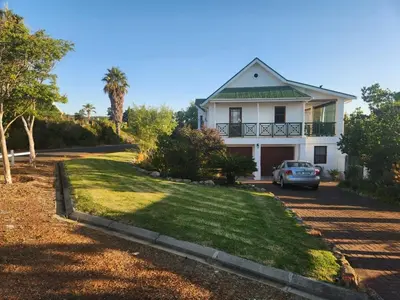 a house with a car parked in the driveway at Fairway Corner in Villiersdorp