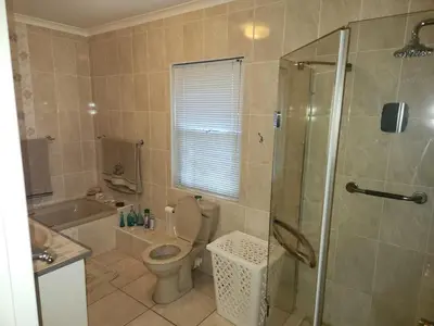 a bathroom with a shower and a toilet and a sink at Fairway Corner in Villiersdorp