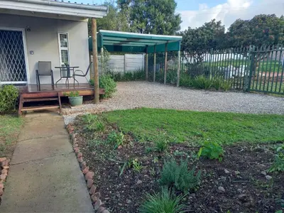a backyard with a bench and a picnic table at 2 on Fifth Avenue in Botrivier