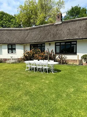 a table and chairs in front of a house at Honeymoon Stay at The James Family Farm in Grabouw