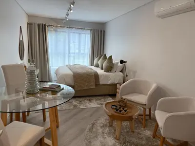 a bedroom with a bed and a glass table at Platform 132 - 2 On Tabak with onsite Parking in Paarl
