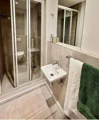 a white bathroom with a sink and a shower at Platform 132 - 2 On Tabak with onsite Parking in Paarl