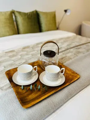 a tray with two cups and a tea kettle on a bed at Platform 132 - 2 On Tabak with onsite Parking in Paarl