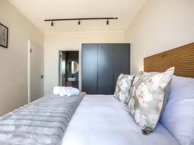 a bedroom with a large white bed with pillows at On Park Century City in Cape Town