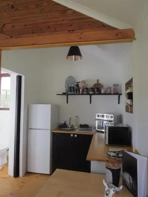 a kitchen with a white refrigerator and a counter at Hoopoe Cottage Horns op de Hoek in Hartebeest Rivier