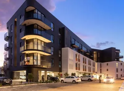 a black building with cars parked in front of it at 1bedroom Luxe Nine Palms near Canal Walk in Cape Town