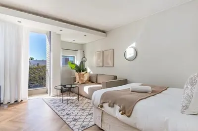 a bedroom with a bed and a living room with a couch at On Park - Century City Lux Studio Apartment in Cape Town