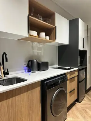 a kitchen with a washing machine and a sink at On Park - Century City Lux Studio Apartment in Cape Town