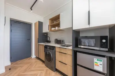 a kitchen with a washing machine and a microwave at On Park - Century City Lux Studio Apartment in Cape Town