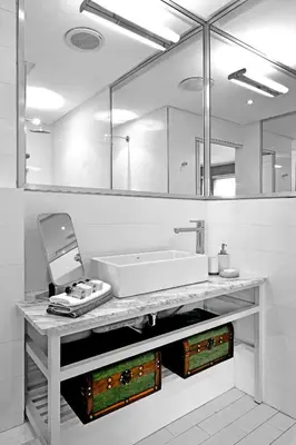 a white bathroom with a sink and a mirror at Le Petit Bijou Aparthotel in Franschhoek