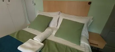 a bed with two green pillows on top of it at Ojong's Self-Catering Ridgeworth - Bellville in Tyger Valley
