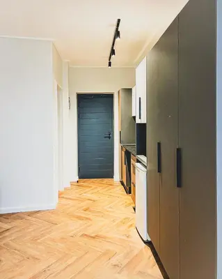 a kitchen with a blue door and a wooden floor at Luxe Studio - On Park near Canal walk Century City in Cape Town