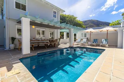 a swimming pool in front of a house at Escape to Hermanus Spacious Family Home in Hermanus