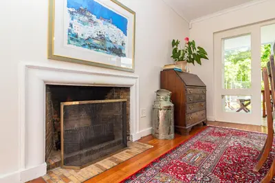 a living room with a fireplace and a rug at Escape to Hermanus Spacious Family Home in Hermanus