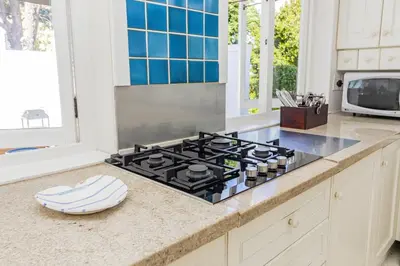 a kitchen counter with a stove top in a kitchen at Escape to Hermanus Spacious Family Home in Hermanus