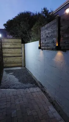 a fence with a wooden gate and a brick wall at Beach Pebble - 200m walk to beach kite surfer paradise, work friendly, pet friendly - must request in Bloubergstrand