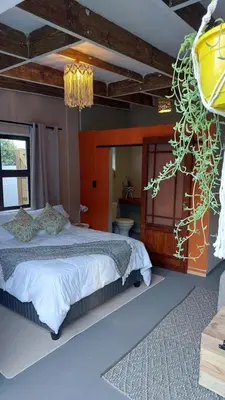 a bedroom with a large bed and a chandelier at Beach Pebble - 200m walk to beach kite surfer paradise, work friendly, pet friendly - must request in Bloubergstrand