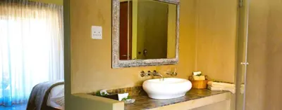 a bathroom with a sink and a mirror at Kapensis Guesthouse II Venue & self-catering in Bettyʼs Bay