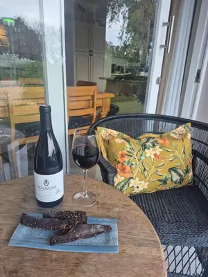 a bottle of wine and a glass on a table at Serendipity 2 Bedroom Family Home in Onrus in Hermanus