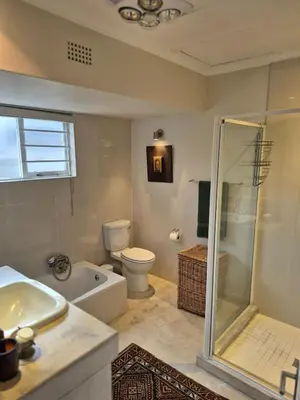a bathroom with a shower and a toilet and a sink at Serendipity 2 Bedroom Family Home in Onrus in Hermanus