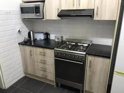 a kitchen with a stove and a microwave at Sunny Spacious Stellenbosch 3 bed garden apartment in Stellenbosch