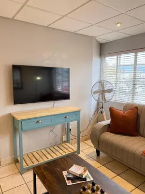 a living room with a tv and a couch at Nunu's Self Catering Apartment in Paarl