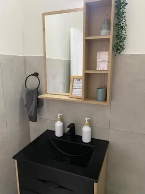 a bathroom with a black sink and a mirror at Nunu's Self Catering Apartment in Paarl