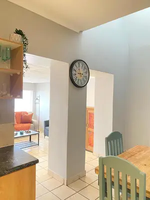 a clock on a wall in a living room at Nunu's Self Catering Apartment in Paarl